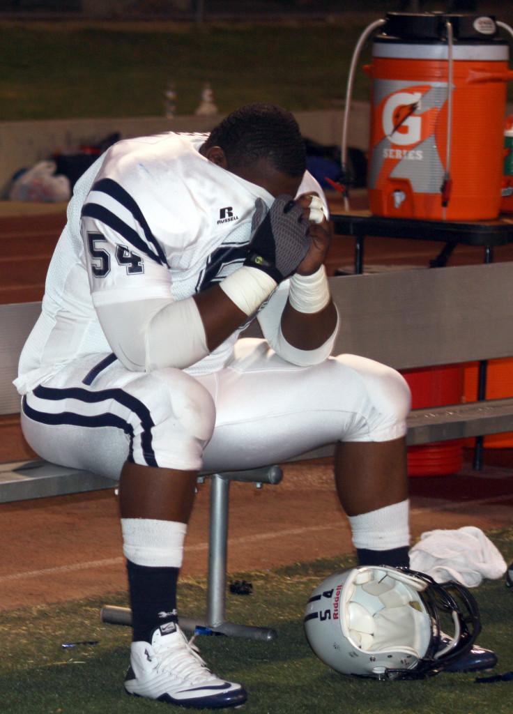 Cerritos College defensive tackle Jerrell Gordon hides his face after the football team was defeated 28-23 by Los Angeles Harbor College on Saturday. The Falcons defense allowed almost 350 yards on the ground. 