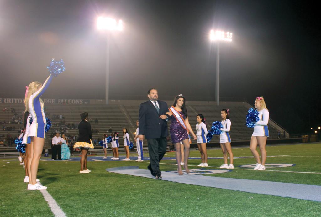 Homecoming queen Raquel Ramirez walks toward the stage in Falcon Stadium with her father, Frank Cruz, on Saturday before being announced as the winner of this years crown. Ramirez was representing the iFalcon club