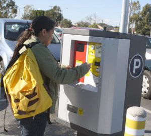 Zoology major Lupe Barron is using a new daily parking permit dispenser in a parking lot at Cerritos College. The dispensers are being used on a trial basis from Feb. 1 until the end of March.