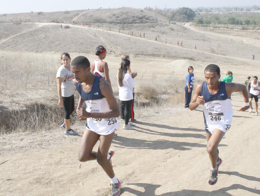 Sophomores Brandon Taylor (left) and Munir Kahssay (right) lead the race coming over a steep hill in the first leg of the race. Kahssay finished No. 2 and Taylor No. 3