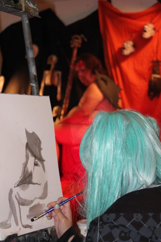 Art major Melissa Duran draws nude model Michael Sscmidt on paper for her life drawing art class. Since the class is on Halloween, the instructor arranged to have a Halloween-themed model to come in to class.
