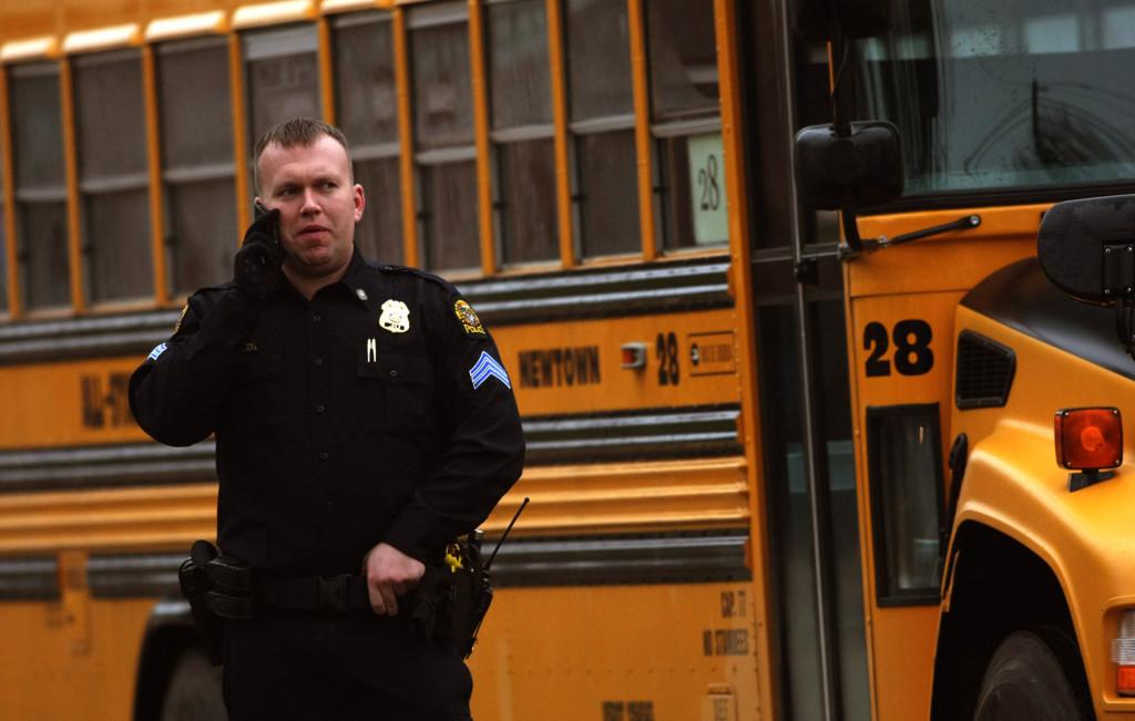 A police officer keeps vigil as students are dropped off at the Newtown Middle School as classes resume in Newtown, Connecticut, Tuesday, December 18, 2012. Newtowns public schools opened for the first time since last weeks shooting, but with police stationed at entrances both to reassure parents and pupils. (Genaro Molina/Los Angeles Times/MCT)

