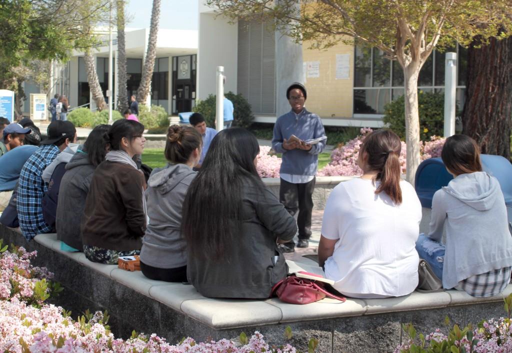 Earl Roy leads the Alpha Omega club in a Bible study in Falcon Square on Wednesday.