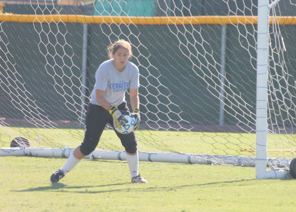 Sophomore goalkeeper Alexis Carrillo intercepts the ball and prevents it from entering the goal while doing a soccer drill during practice. She torn her ACL last season and is getting better as the season goes on.