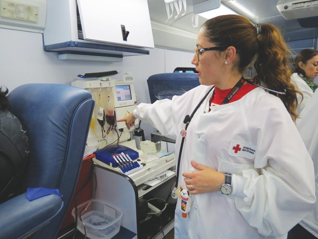 Tiffany Kiggins, an American Red Cross  checks the plasma from a donor.Photo credit: Justine Young.