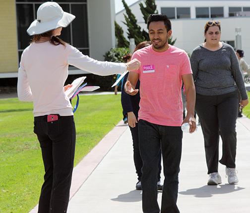 Professor Ni Bueno was at the finish line of the walk giving out information pamphlets to participants. Nestor Hernandes, a business major, is at the end of his walk which he finished in less than thirty minutes.