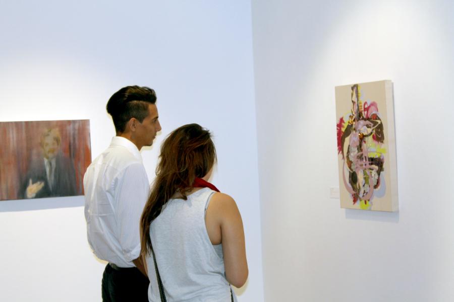 Jose L. Centeno, graphic design major, looks at one of the many pieces of art with a friend in the Savage Sentamentality portion of the art gallery. The art gallery featured artist outside of Cerritos College. Photo credit: Luis Guzman