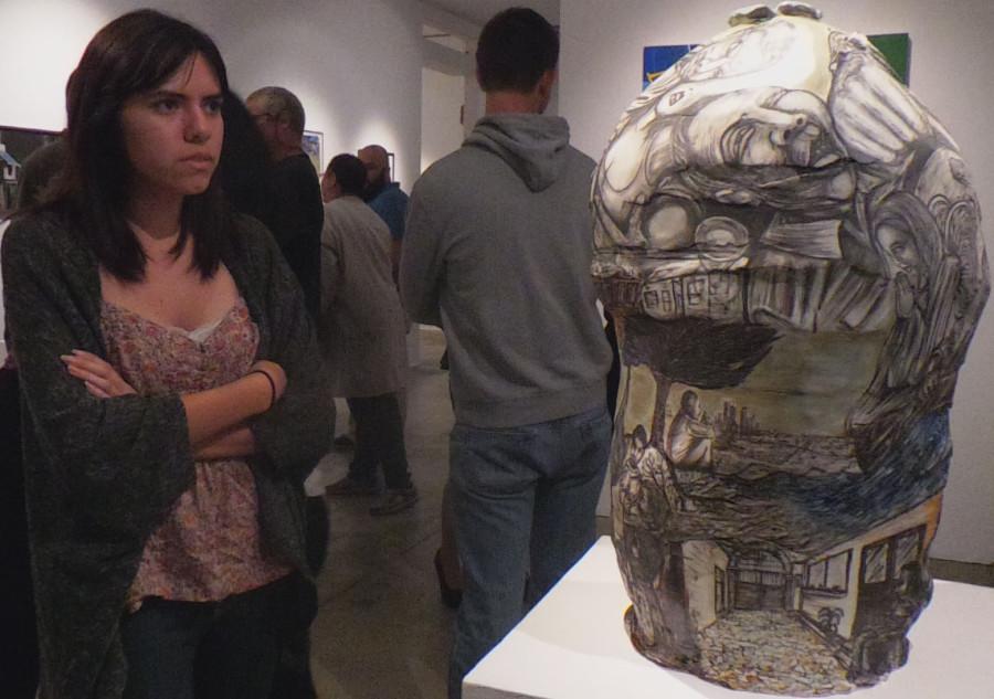 Fine Arts major Davina Romero looking at Gerardo Monterrubio porcelain sculpture Torito