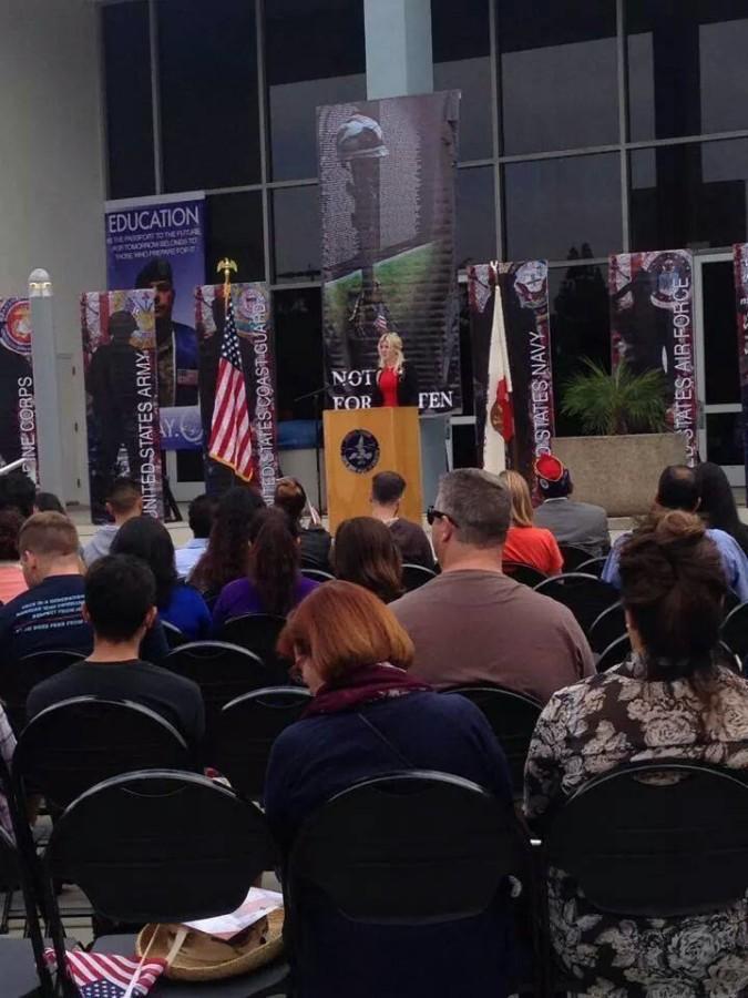 In the distance, Hope Garcia, speaks at a Veterans Day event on campus.