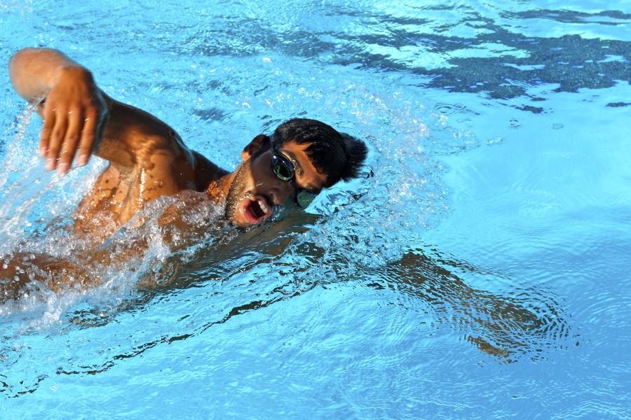 Backstroke swimmer, Marlon Moreno, warms up during swimming practice. Photo credit: Emily Curiel
