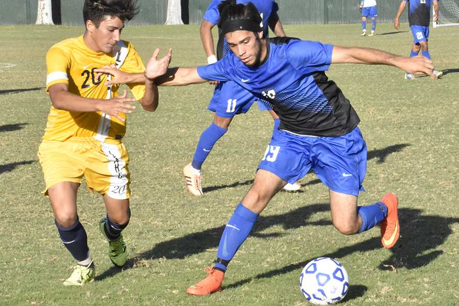 Number 19 forward/midfielder Nathan Martin keeping the ball a way from Los Angeles Harbor College player number 20 Erick Nuno. Cerritos won the game with a score of 3-2. Photo credit: Perla Lara