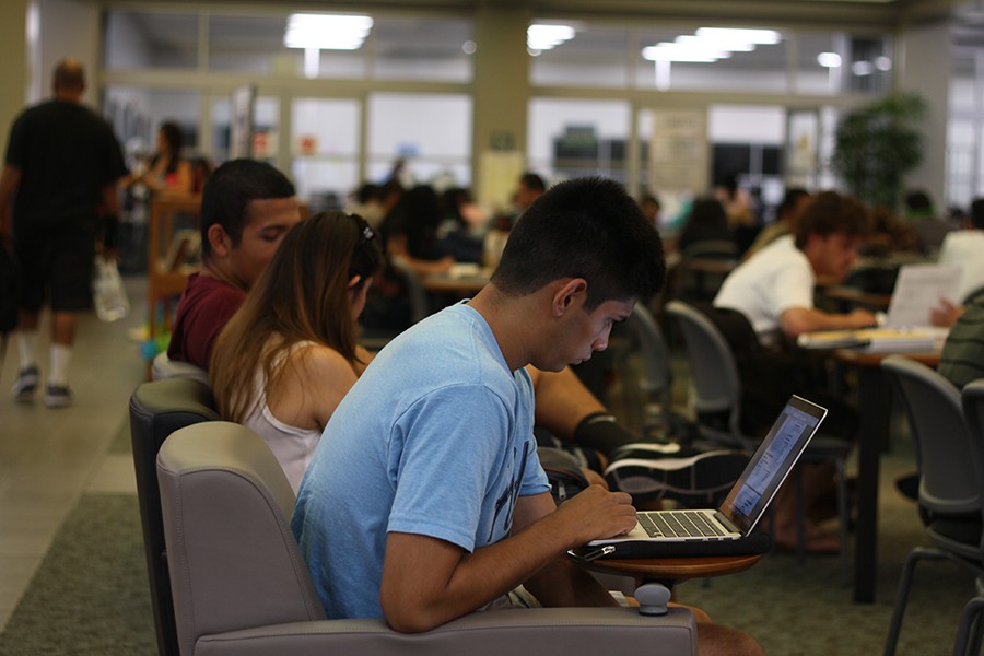 Jason Guerrero, engineering major, studies in the relatively full library as two students chat nearby. To combat the traffic and noise, the library staff has also added additional tables in the main entrance. Photo credit: Karla Enriquez