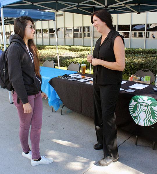 Psychology major, Kealani Infiesto (left) speaks with Store Manager of the Starbucks located in Imperial and La Mirada (store number 5716), Kimberly Hammond (right), about their hours, hourly rate and to see if it would be lucrative to transfer. Infiesto is currently a part-time student and she definitely wants more hours, 401K and wonderful benefits, which is what shes looking for. Photo credit: Bianca Salgado