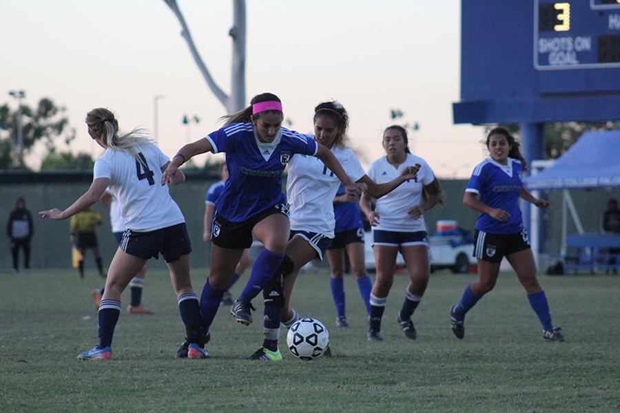 Freshman Natlie deLeon dribbles through two of El Caminos defenders. She leads the team with fifteen assists in the season. Photo credit: Christian Gonzales