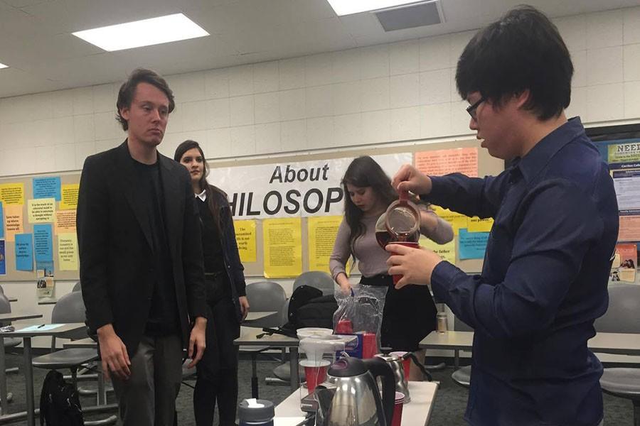 Treasure of the Philosphy Club Joseph (right) Jang pours over a fresh cup coffee as he performs a coffee tasting. Jake Newland (left), vice president of the club, participates with the guests of the event. Photo credit: Kristopher Carrasco