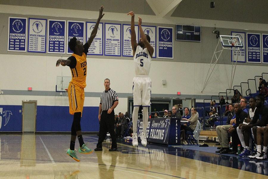 Tyler Payne (#5) shoots a three pointer over Leroy Jones (#2) of Los Angeles Trade-Tech. Payne led all Cerritos scorers with 18 points off the bench, all of them coming on threes.