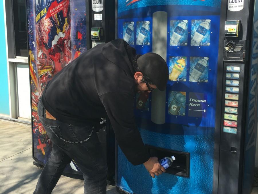 A student grabs a drink from the vending machine. With the Canteen vending machine can easily get access to services and be more aware of the nutritional facts.