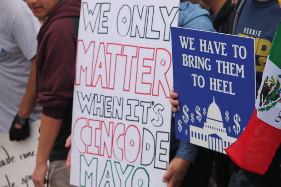 Anti-Hillary Clinton protesters questioned Clintons visit to East Los Angeles College on Cinco de Mayo. The presidential hopeful gave a 14-minute speech inside the gym.