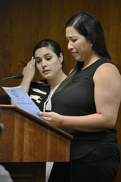 At the Wednesday July 20, Board of Trustees meeting Yhadira Bueno (front) addressed the board members during the comments from the audience portion of the meeting as Christina Galvez (back) stood at her side. With tears in her eyes Bueno told the board members how approximatetly one year ago her child was found by another parent in the Cerritos College parking due to doors being left open. She asked the board to reinstate the five teachers that were fired and fix the faulty door system that alleowed her child and others to go out by themselves. Photo credit: Perla Lara