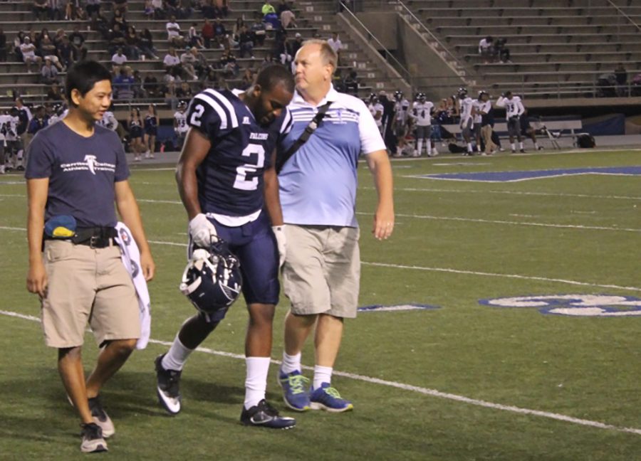 Linebacker Kijon Washington is being assisted off the field by Brian Cable and an assistant after suffering an ankle injury in Saturday nights game. He would later return to the game after recieving treament from the athleteic training staff.