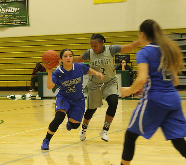 Freshman guard Alondra Calderon fights past ELAC guard Tiffani Martinez as she attempts to send a pass to teammate Angie Ferreira. The Wednesday, Jan. 11 game ended with 81-47 loss for the Falcons. Photo credit: Monique Nethington