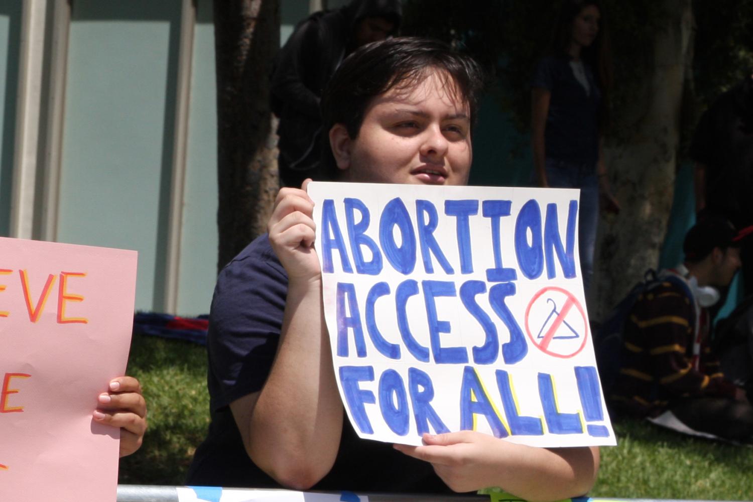 Anthropology major Charles Petersen, protesting the Center for Bio-Ethical Reforms anti-abortion demonstration at Cerritos College on Monday. Petersen is a transgender student that values the freedom of choice. Photo credit: David Jenkins