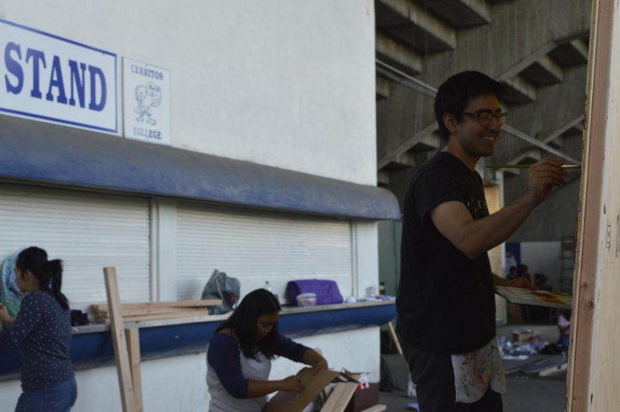Accounting Clubs Tony Gasca, art major, helping fellow accounting major classmates Jilliane Tapel and Gechchou Kim by painting the backdrop of their float. Students from various clubs create floats for Cerritos Colleges 2017 Homecoming. Photo credit: Carlos Martinez