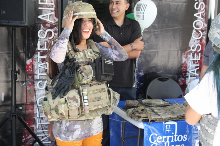 Kemberly Enriquez trying on army gear with the permission of the veterans. Enriquez and the Homecoming Queen Jazmine Jose were taking pictures wearing the gear. Photo credit: David Jenkins