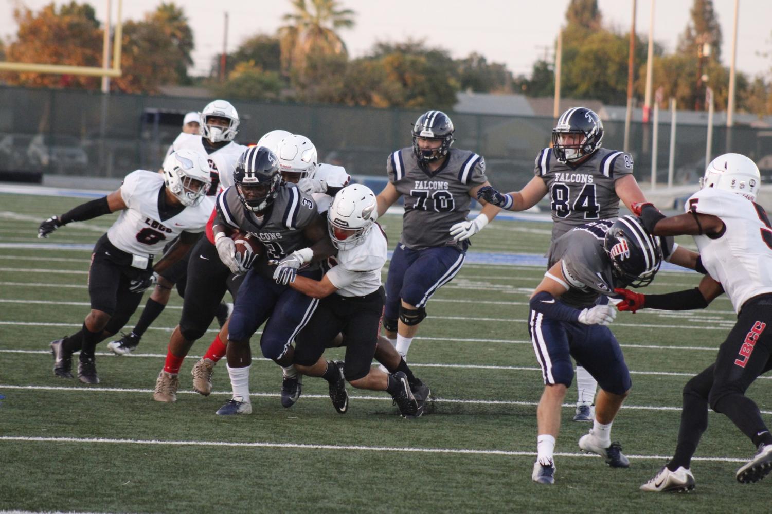 Sophomore running back No. 3 Rhamondre Stevenson carrying the defensive line on his back and pushing through to gain yardage. Stevenson set the Falcons school record in single-game rushing yards with 339 in the game at Cerritos College against Long Beach City College on Sept. 29, 2018.