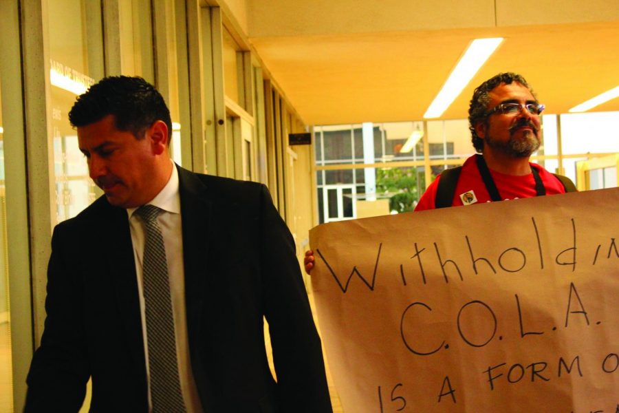 Withholding of C.O.L.A. is a form of embezzlement read Walter Fernandezs sign as Vice President of Business Services Felipe Lopez walked by. Faculty members, both part-time and full-time alike and union members were present, wearing red shirts at the Sept. 19 Board of Trustees meeting.