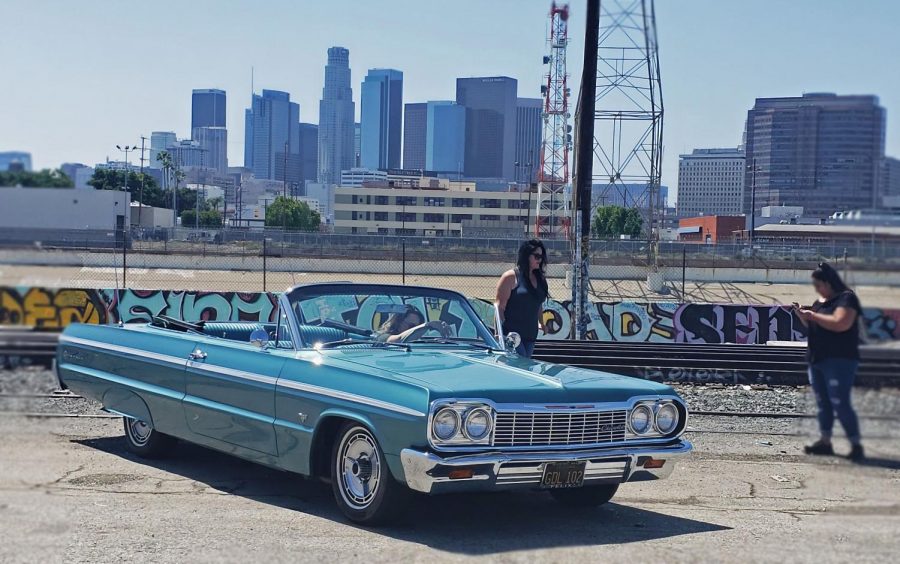 Las chicas gather around this beautiful classic top-down in front of the Los Angeles skyline. The perfect car to take to the beach. 