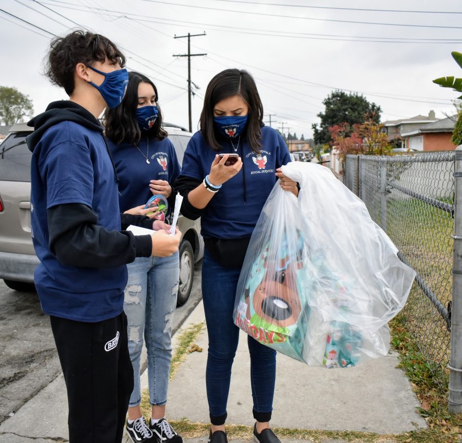 Childcare coordinator Jenifer Friesens children Jeffery Rivera (left), Briana Rivera (middle) and Ellie Delgado (right), attempt to contact the family receiving an Angel Tree gift on Dec. 12. Any family that was supposed to receive a gift but did not is urged to contact Norwalk Social Services department.  