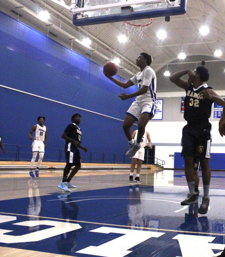 Sophomore Point Guard no.2, Joshua Belvin, elevates under the rim to score a hard-worked two points. The basketball team is eager and prepared to go back to practice and start competing in games. Photo credit: Keanu Ruffo