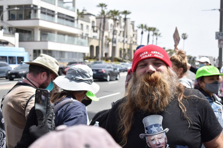 A Trump supporter taunts an anti-racist counter-protester at the Huntington Beach Pier. The counter-protest was organized to prevent a KKK rally on April 11, 2021.