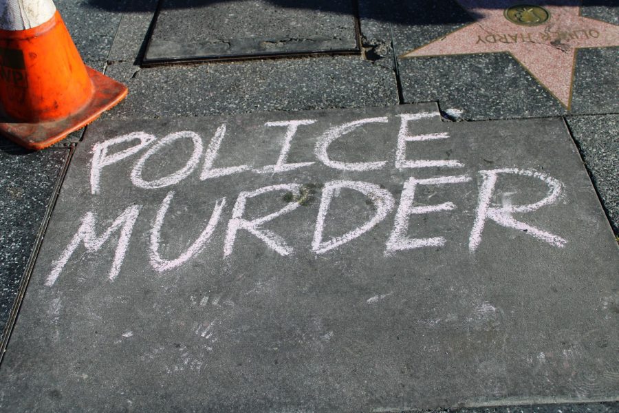 A vigil is made in West Hollywood response to the killings of Daunte Wright and Adam Toledo. Police murder is written in chalk on the concrete in front of the memorial on April 18, 2021.