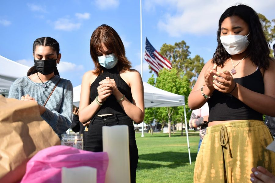 Juliana Silva (left), Laurane Garrido (middle) and Rachel Huh (right) hold a candlelight vigil for the victims of AAPI hate crimes. They hold their vigil and rally on April 24, 2021. 