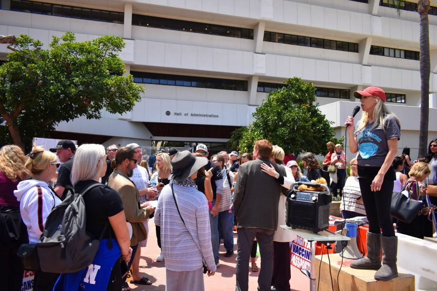 Martina Bowersox speaks to a maskless crowd as they protest the voluntary digital vaccine passport on May 11, 2021. Many protesters compared the voluntary passport to a Nazi regime. 