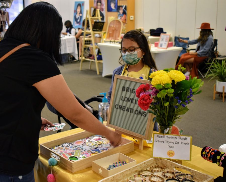 Mia Mateos, 8, sells her handcrafted jewelry from her business Bright Lovely Creations, during a pop-up event in Norwalk Town Square on May 15, 2021. She made the jewelry using beads, and sold stickers as well. 