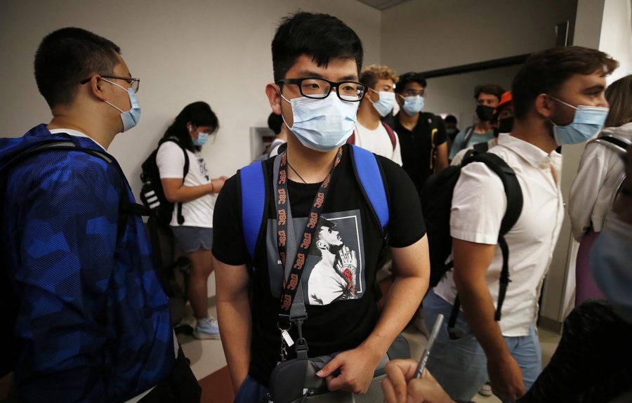 Sophomore student Khoa Nguyen waits with other students to enter a classroom on the USC campus Monday, August 23, 2021 for the first day of in-person classes. USC and California State University campuses start in-person classes on Monday, serving as a test case for whether vaccine mandates, masking, regular testing and other protocols can minimize spread of the Delta variant even as thousands of students congregate in classes, dorms and social events. Photo credit: Al Seib/Los Angeles Times/TNS