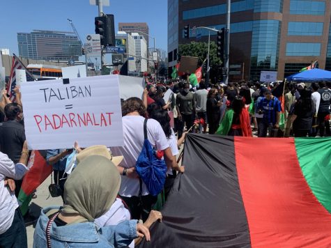 Protestors march towards US Federal Building while holding an Afghan flag to stand with Afghanistan. On Aug. 28th a protestor holds a poster saying "Taliban = padarnalat", which translates to "bastard" or "lowlife" in Farsi.