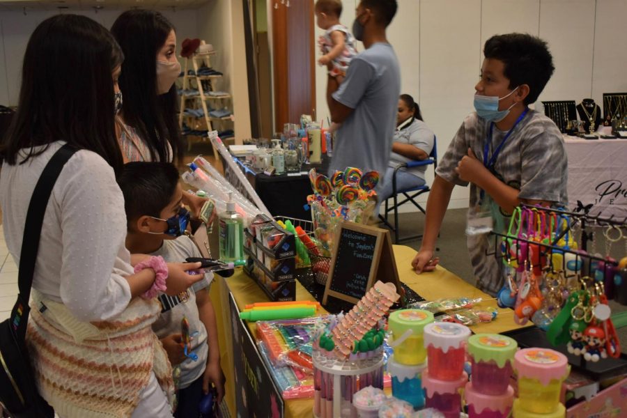 Jaden Avila, 10, sells his products to customers during a small business pop-up event on Aug. 28, 2021. He sells slime, key chains and toys at his business, Jadens fun zone. 