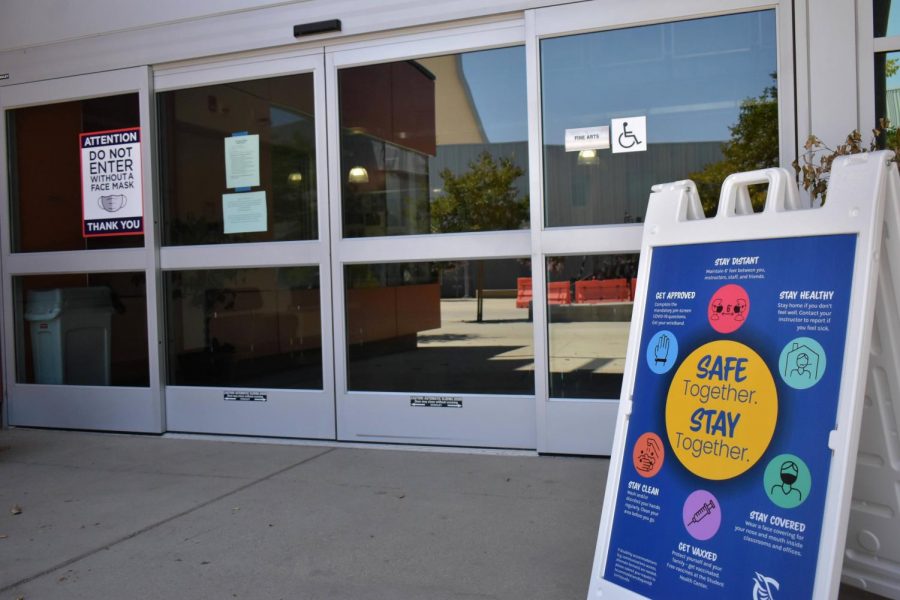 Signs are placed outside Cerritos College buildings and facilities reminding everyone to wear a mask and get vaccinated. The Cerritos College Board of Trustees proposed revisions to the vaccine mandate policy during their meeting on Sept. 15, 2021. Photo credit: Vincent Medina