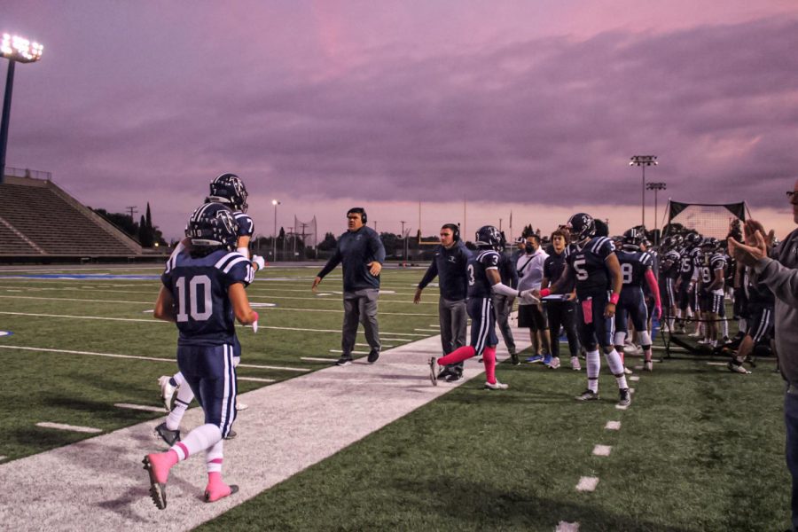The+Cerritos+Offense+heads+to+the+sideline+after+Running+Back+Davon+Booth+%236+Scores+the+first+Touchdown+of+the+game+for+the+Falcons.+Several+Cerritos+players+are+seen+high-fiving+teammates+and+coaches+as+they+make+their+way+towards+the+sideline+in+the+first+quarter+of+the+game+on+Oct.+23%2C+2021.+