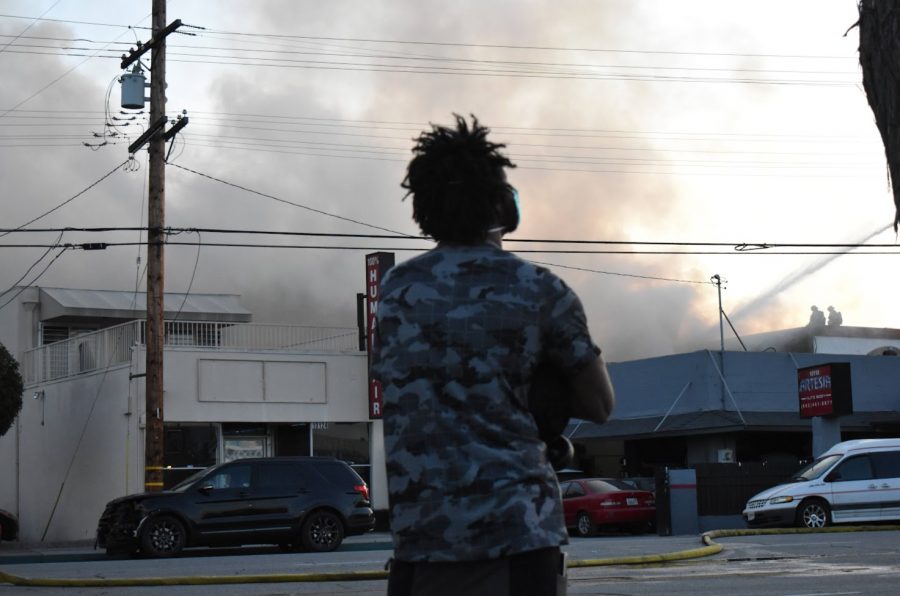 Dwayne Lofton watches firefighters work to put out a fire that is threatening his hair product business, Expose. No other buidlings were damaged by the fire on Nov. 9, 2021. 