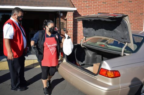 Salvation Army volunteers observe COVID-19 safety protocols and place the Thanksgiving meal in patron's car. They organized their drive-thru charity event on Nov. 23, 2021.