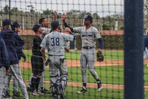 No. 50, J'amore' Ward celebrating with teammates and coaches after striking out the side, and coming off the mound against Fullerton on Jan. 29, 2022.