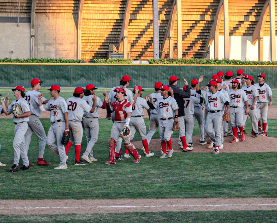 The Dons take to the field and celebrate the 11-4 win against the Falcons at Cerritos. Santa Ana lines up to give high fives all around their teammates on Feb. 8, 2022. 