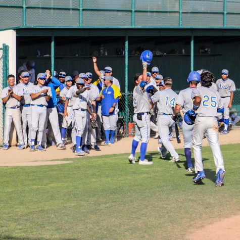 Wildcats dugout celebrates at the top of the ninth inning after Kai Hersberger hits a three-run homer to put West LA up 12-7. The Wildcats cheer him on as he returns to his dugout against Cerritos on Feb. 19.