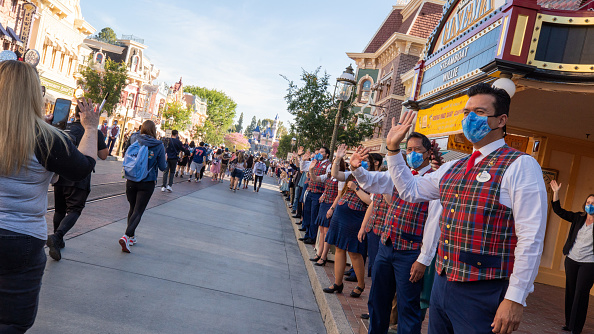 ANAHEIM, CA - APRIL 30: In this handout photo provided by Disneyland Resort,  Guests as are waved to by workers as they take in the sights and sounds of Main Street U.S.A. at the Disneyland Resort on April 30, 2021 in Anaheim, California. Guests are being welcomed back as Disneyland Park, Disney California Adventure Park and Disney's Grand Californian Hotel & Spa are reopening. 