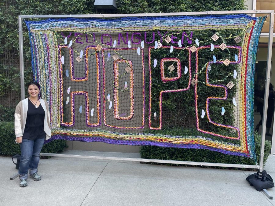Artist Yeu Q Nguyen stands proudly in front of her piece “Weaving Hope” right outside Porto’s in Downey. Photo credit: Silas Bravo